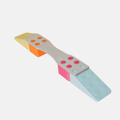 Aktivitäts-Bundle: graues Wackelbrett auf orangem, pinkem und blauem EPP-Baustein, mit bunten Noppen in Gelb, Orange, Pink.